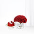 Vibrant red roses and matching cake in minimalist white setting.