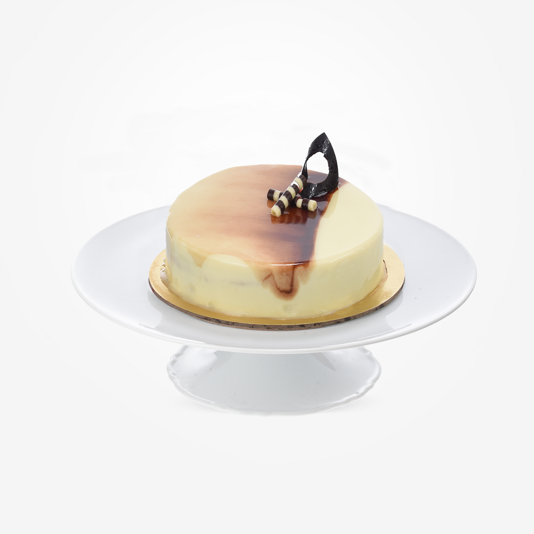 Creamy cake with glossy caramel drizzle and chocolate garnish on white stand.