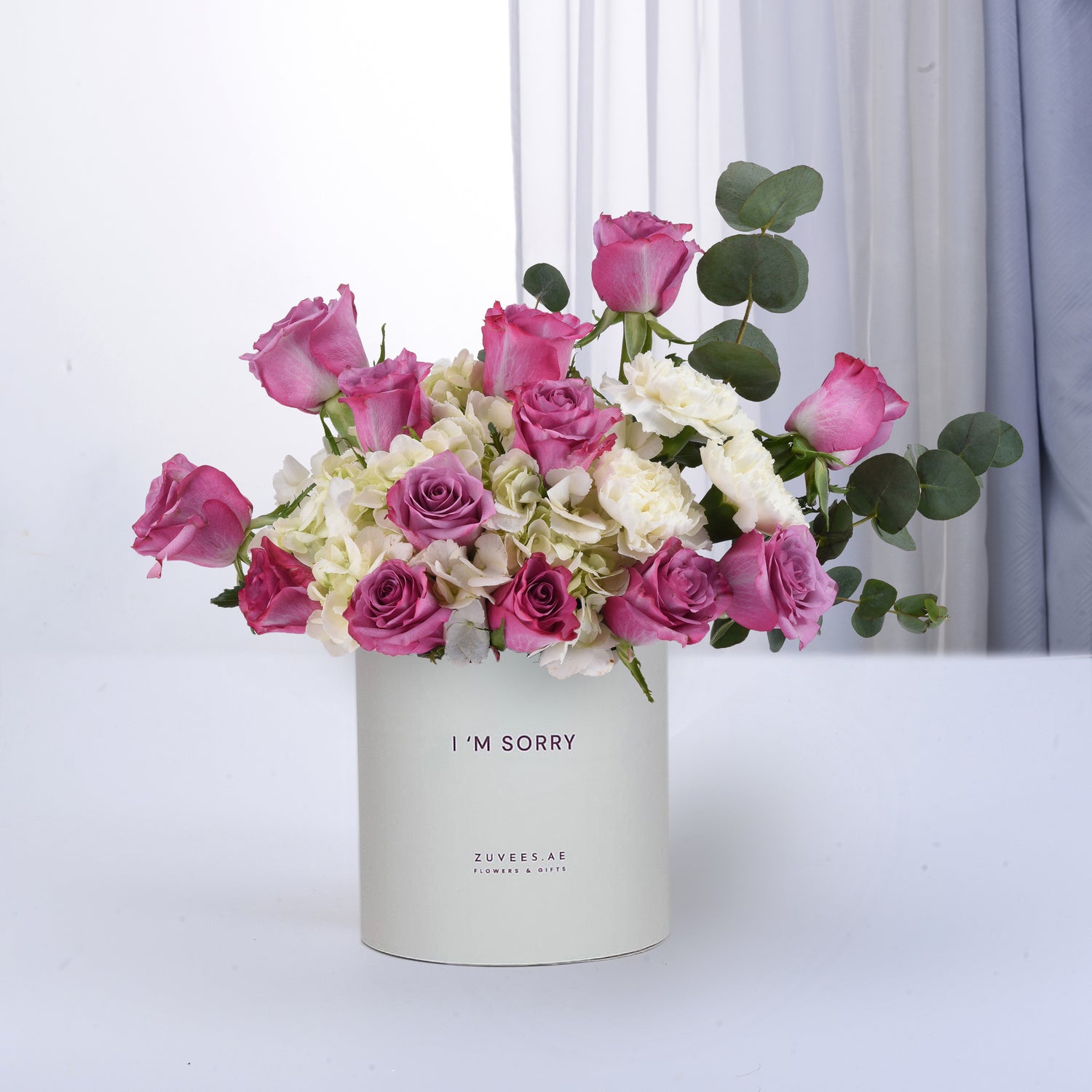 Pastel pink roses, white hydrangeas, and eucalyptus in a "I&