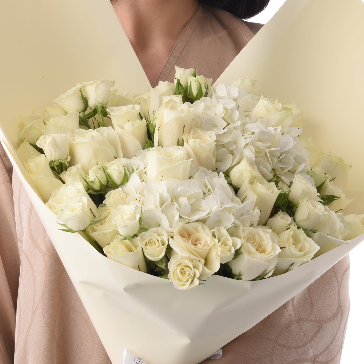 Elegant white rose and hydrangea bouquet wrapped in creamy paper.