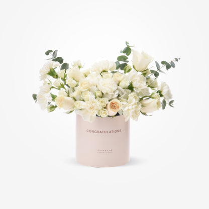 Elegant white rose and eucalyptus bouquet in blush "Congratulations" cylinder.