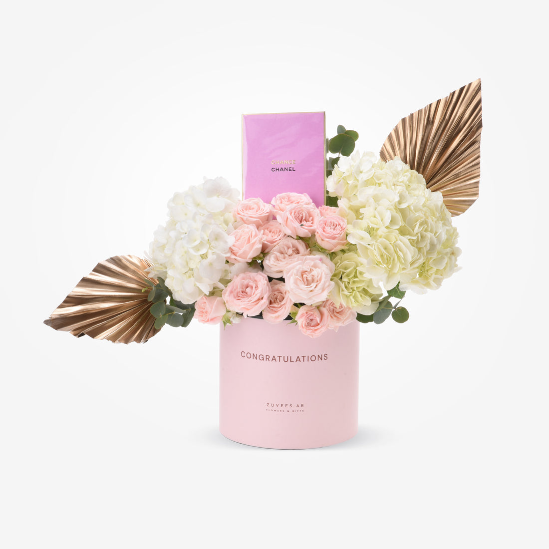 Pink "Congratulations" vase with blush roses, white hydrangeas, gold leaves, and Chanel perfume.