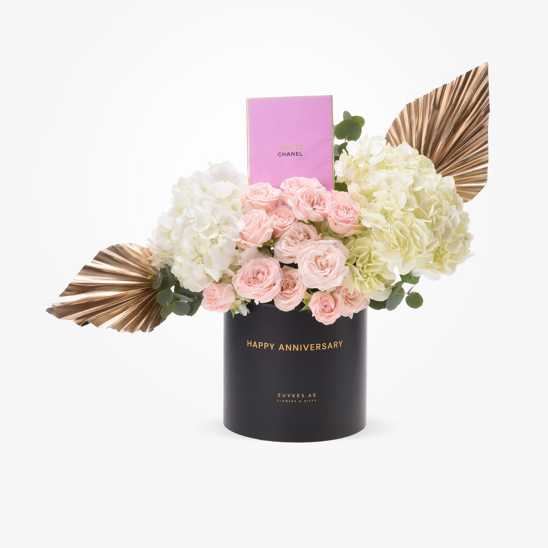 Elegant anniversary bouquet with pink roses, white hydrangeas, gold leaves, and Chanel perfume in sleek black container.