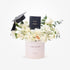 Elegant white floral graduation gift with Chanel perfume and mortarboard in blush box.