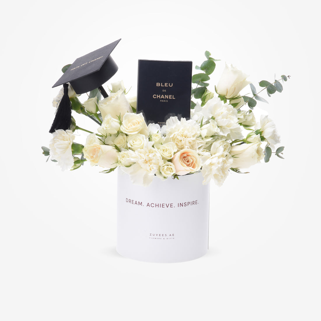 White floral graduation gift with Chanel perfume and black cap.
