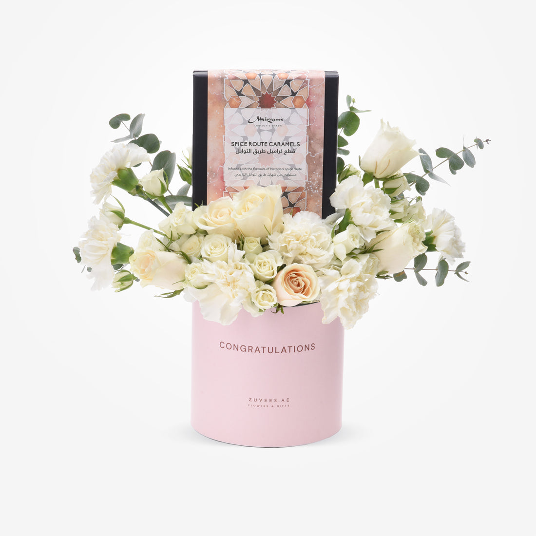 Pink "Congratulations" cylinder holds white roses, eucalyptus, and spice caramel gift box.