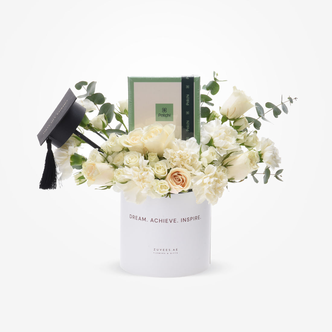 Elegant white floral graduation gift with mini cap and Patchi candle.