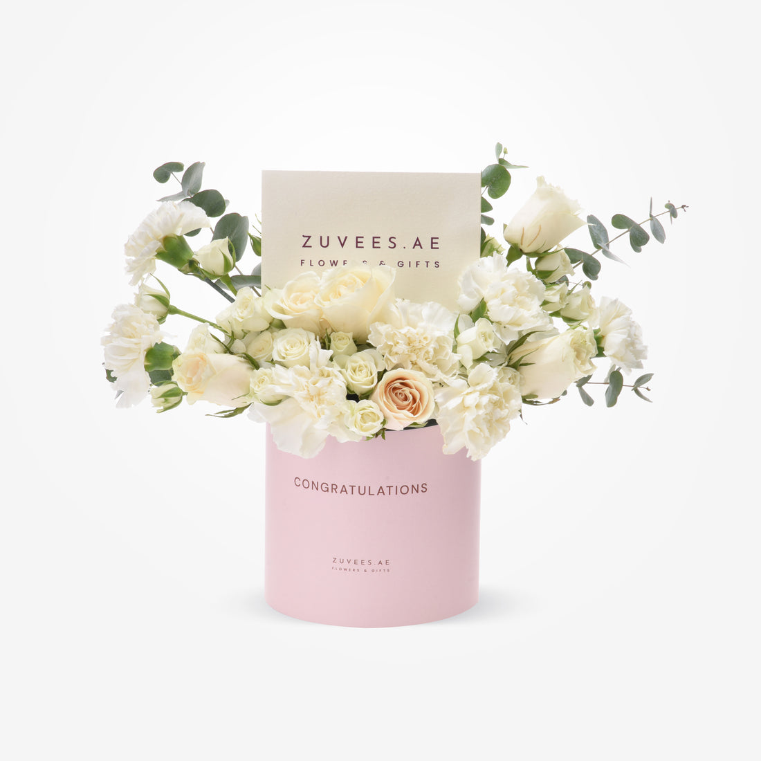 Elegant white roses, carnations, eucalyptus in pink "Congratulations" box by Zuvees.AE.