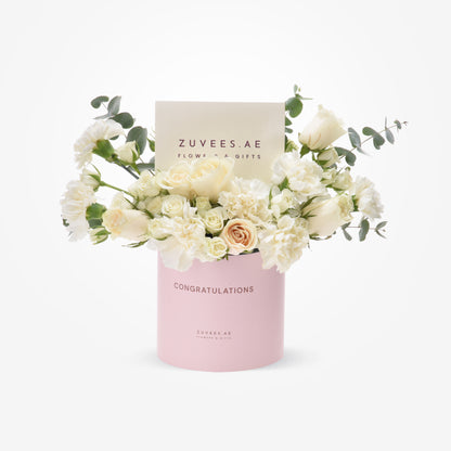 Elegant white roses, carnations, eucalyptus in pink "Congratulations" box by Zuvees.AE.