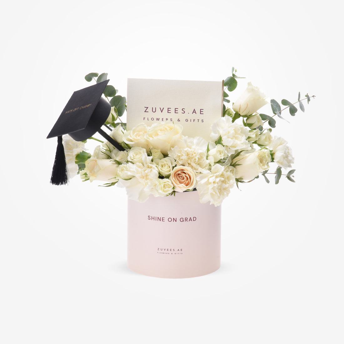 Elegant white roses and eucalyptus in blush box, graduation cap accent.