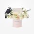 Elegant white roses and eucalyptus in blush box, graduation cap accent.