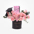 Pink roses and carnations in black graduation-themed vase with “Hats Off Champion” text.