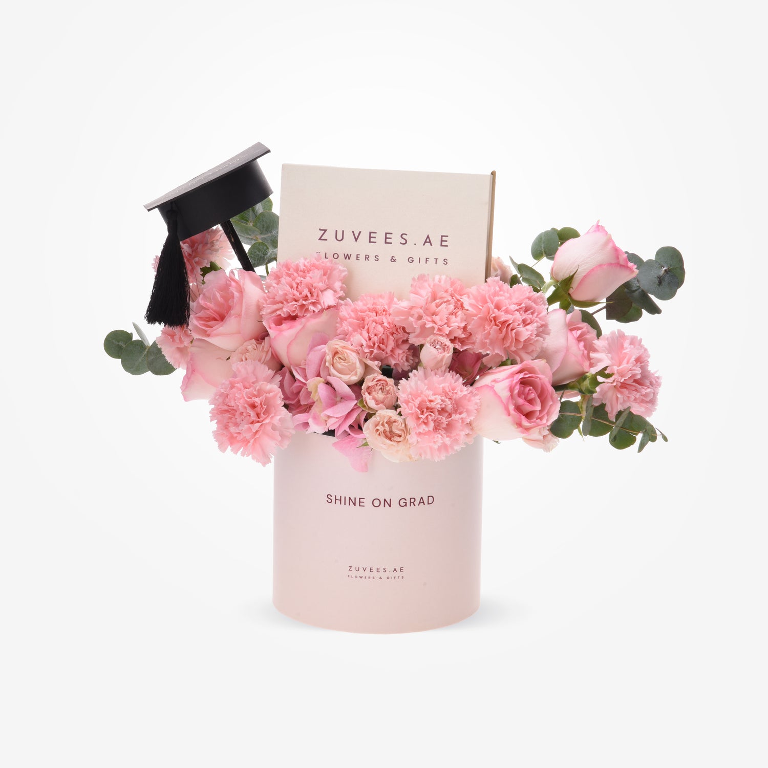 Soft pink roses and carnations in a "Shine On Grad" cylinder, topped with a graduation cap.