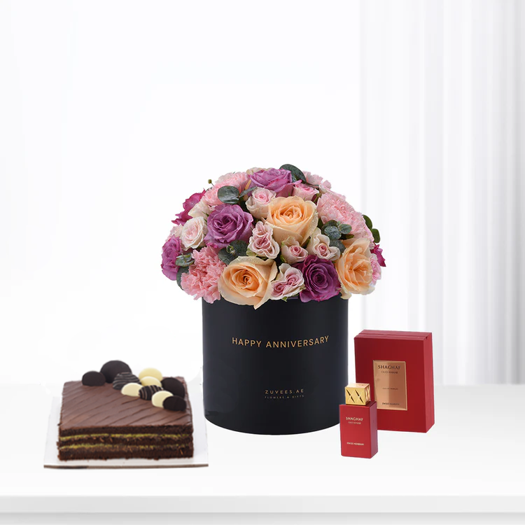 Elegant anniversary gift: floral bouquet, chocolate cake, and luxury perfume set.
