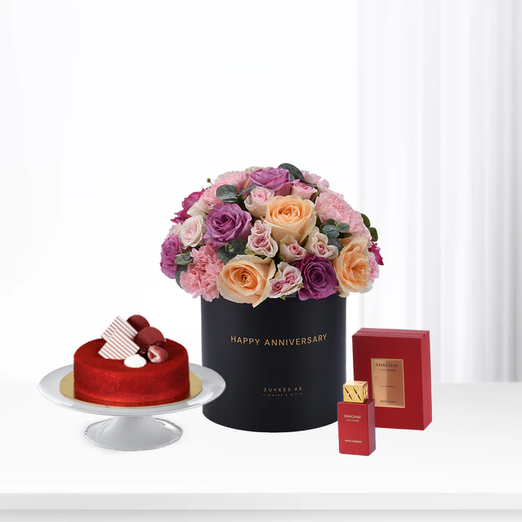 Elegant anniversary gift set: floral bouquet, red velvet cake, luxury perfume.