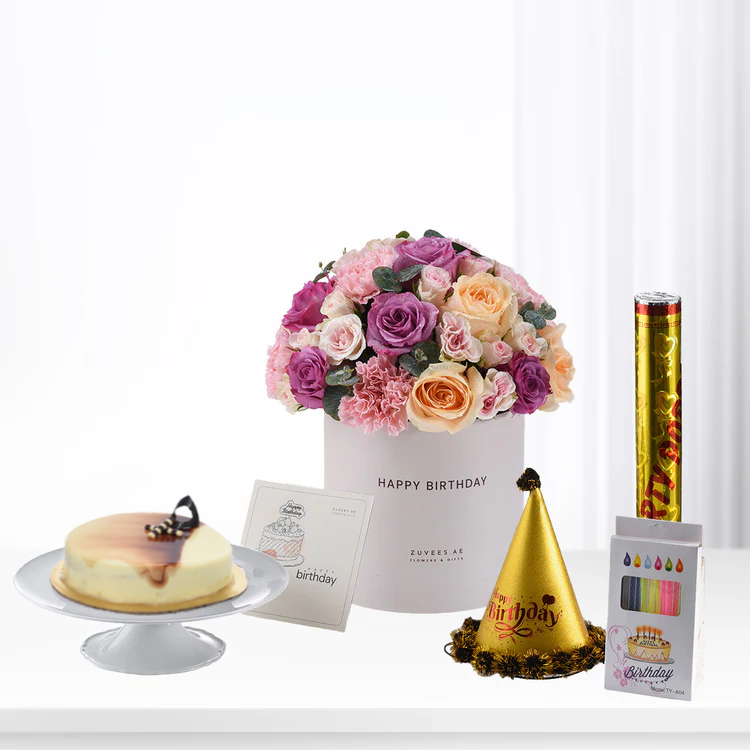 Pink, purple, peach roses in white box with cake, party hat, and confetti.