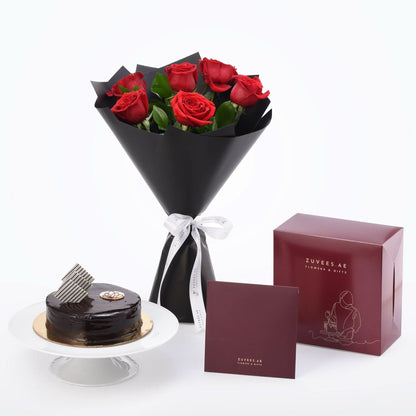 Luxurious red roses in black wrap paired with chocolate cake and branded gift boxes.