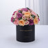 Black box holds vibrant pink, purple, and peach roses with "Happy Anniversary" gold text.