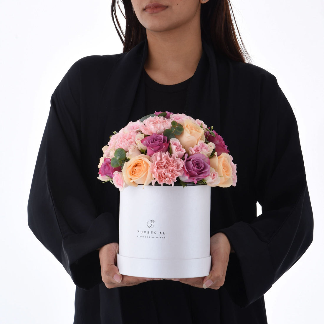 Elegant white hat box filled with soft pink, peach, and purple roses and carnations.