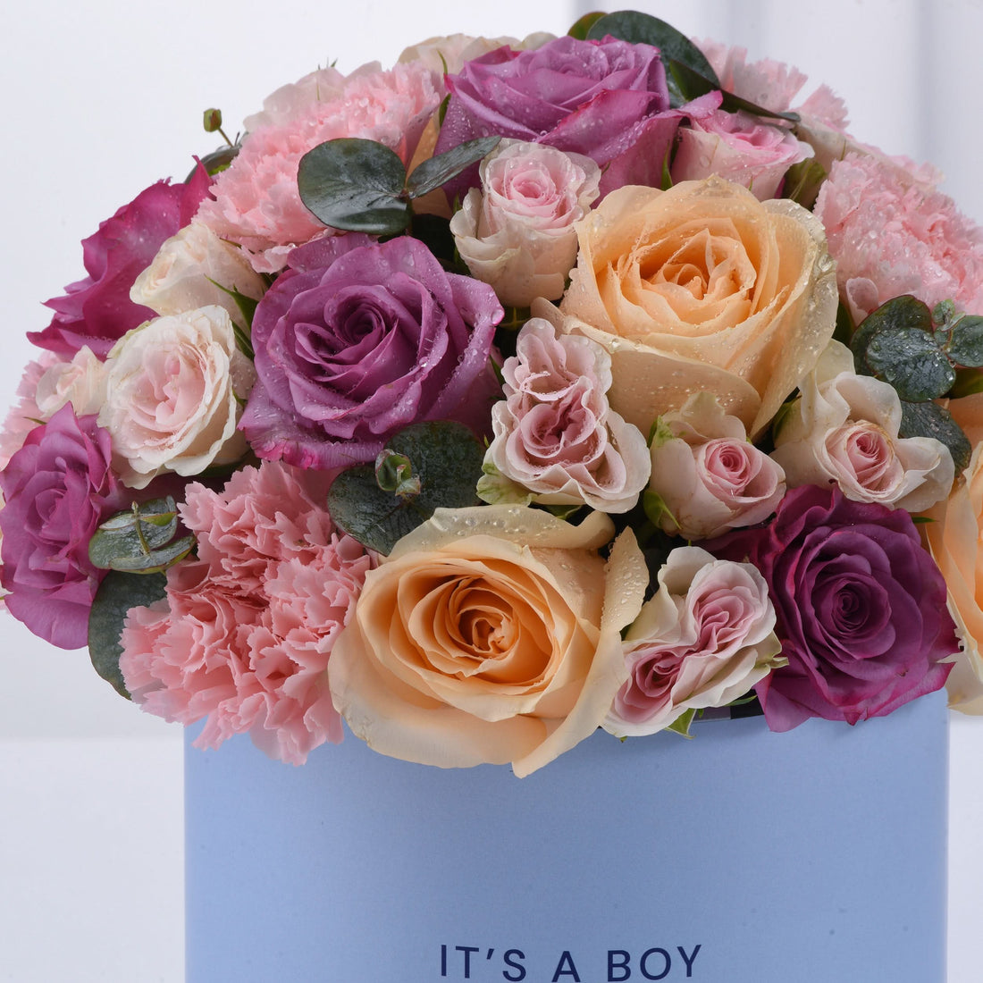 Pastel pink, purple, and peach roses with carnations and dewdrops in a blue "It&