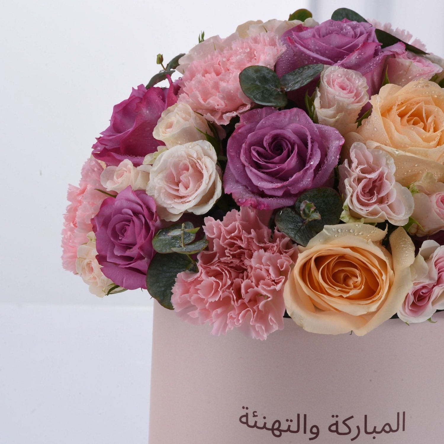 Pink, purple, and peach roses with carnations, dewdrops, and Arabic "Congratulations and Best Wishes" text.