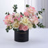 Elegant pink and cream roses with carnations in black “Happy Anniversary” vase.