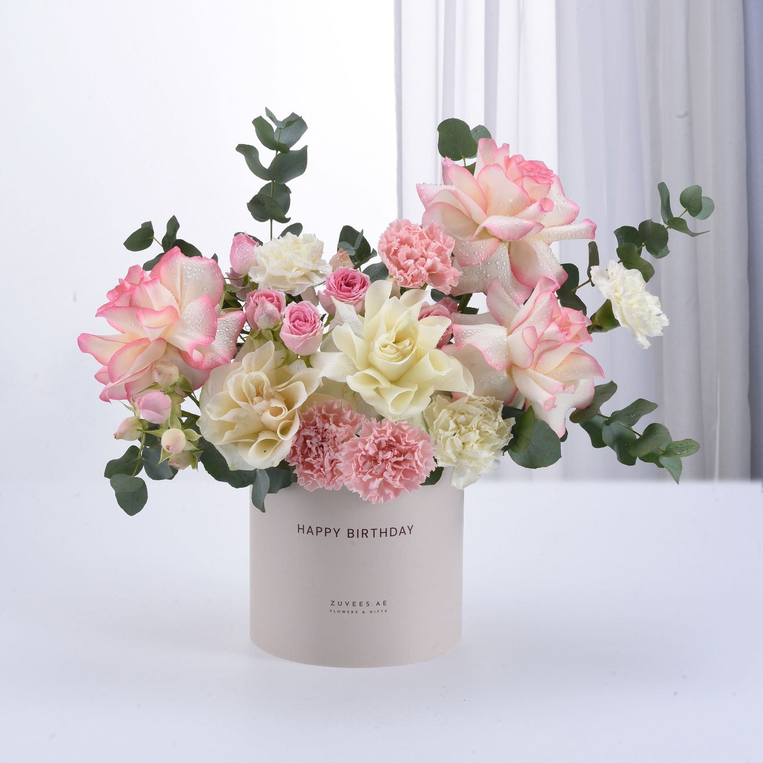 Pastel pink and cream roses with carnations in a "Happy Birthday" cylinder vase.
