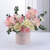 Pastel pink and cream roses, carnations, and eucalyptus in a "Congratulations" box.