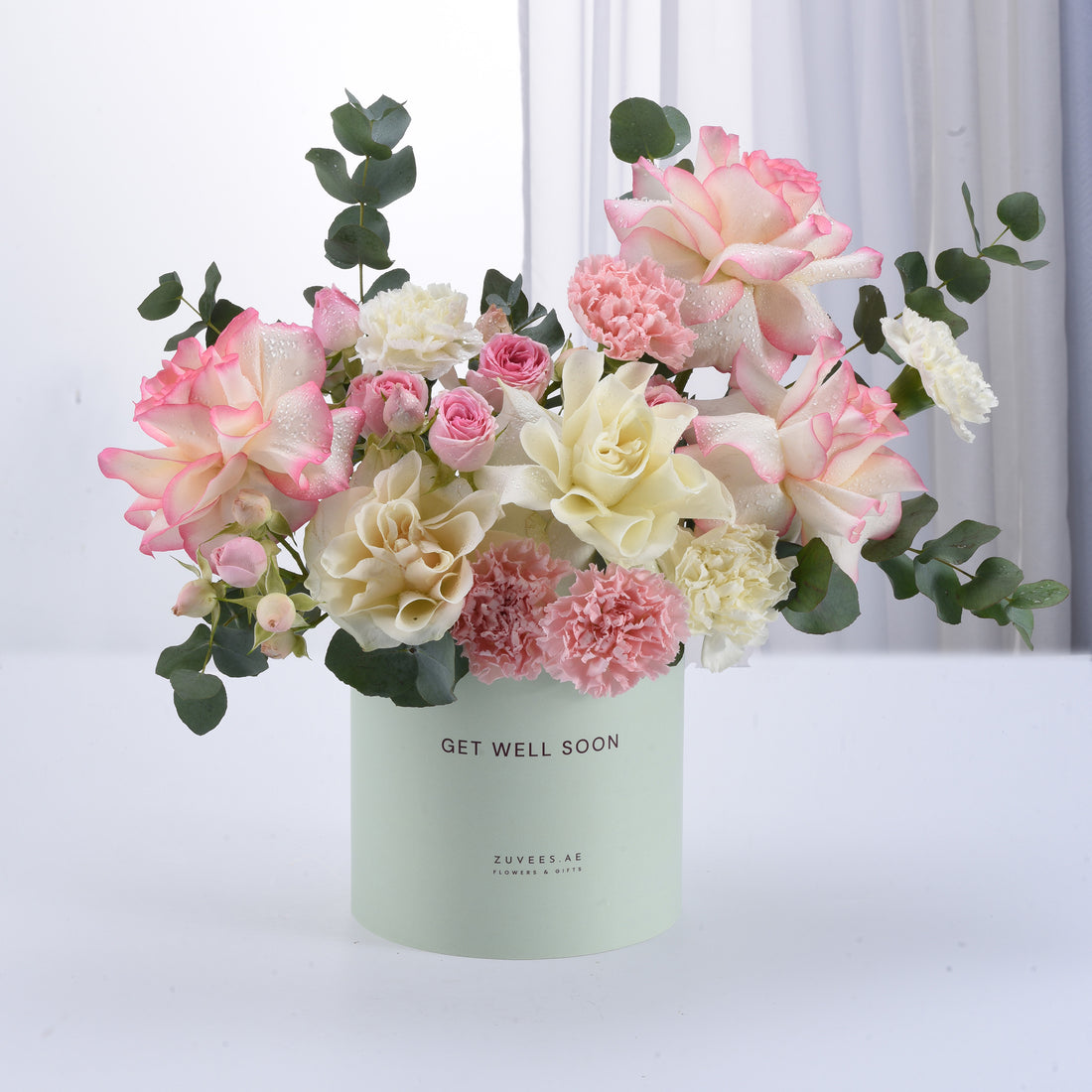 Pastel pink and cream roses, carnations, and eucalyptus in mint "Get Well Soon" vase.