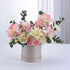 Soft pink and cream roses with carnations in elegant beige box.