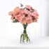 Pink roses in clear glass vase, soft lighting, minimalist decor.