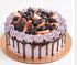 Purple berry cake with chocolate drizzle and fresh fruit topping.