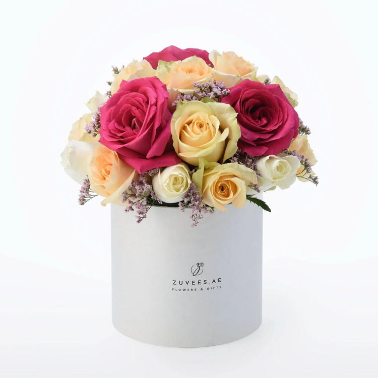 Vibrant pink, yellow, and white roses in sleek white box with "ZUVEES.AE" branding.