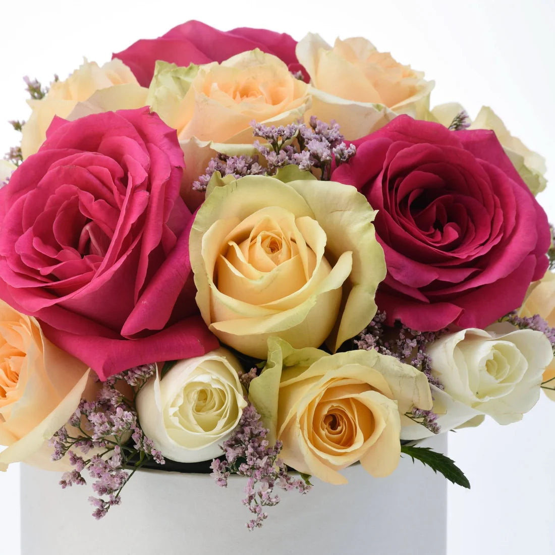 Vibrant pink, peach, and cream roses accented with lavender filler in minimalist white box.