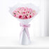 Pink roses in white wrap with dewdrops, tied with branded ribbon, elegant gift bouquet.