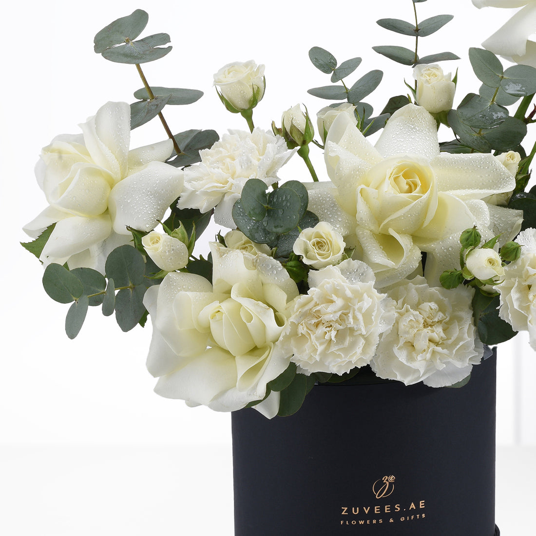 Elegant white roses and carnations with dewdrops in sleek black vase.