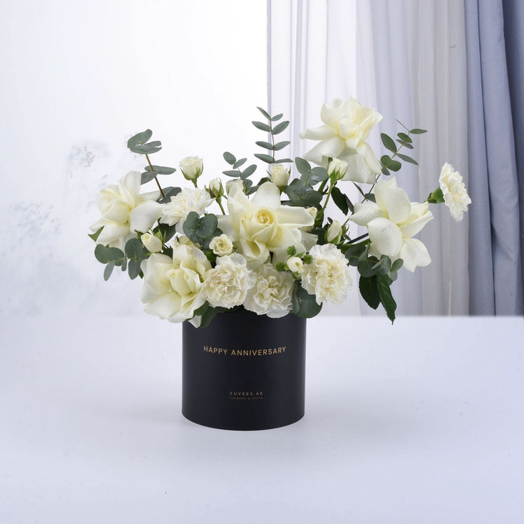 Elegant white roses and eucalyptus in matte black "Happy Anniversary" vase.