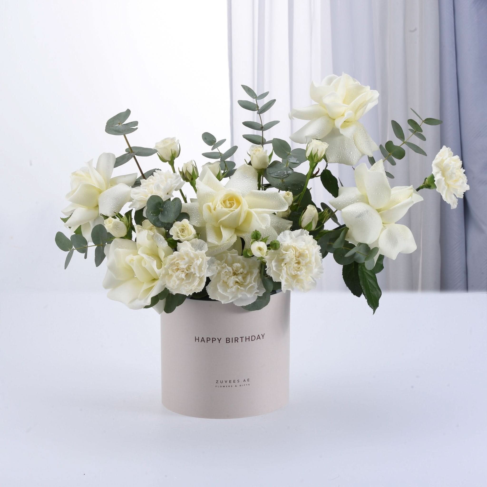 Elegant white roses and eucalyptus in a "Happy Birthday" gift box.