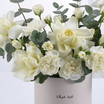 White roses and carnations with dewdrops in minimalist vase.