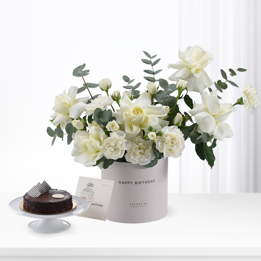 Elegant white roses and eucalyptus in gray "Happy Birthday" box with chocolate cake.