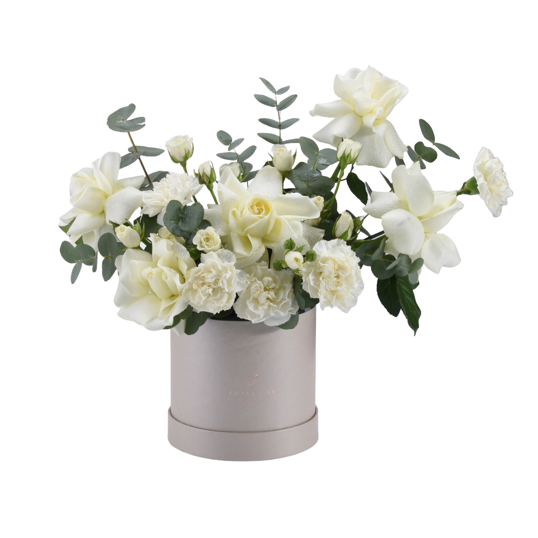 Elegant white roses and eucalyptus in matte silver cylinder vase.