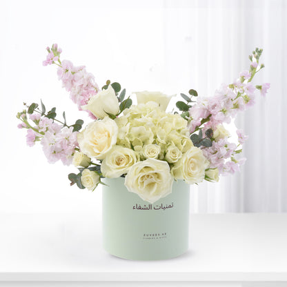 Elegant white roses, pink stock, and hydrangeas in mint green Zuvees box, soft light, luxury floral gift.