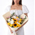 Vibrant sunflowers, roses, and chrysanthemums in creamy wrap.