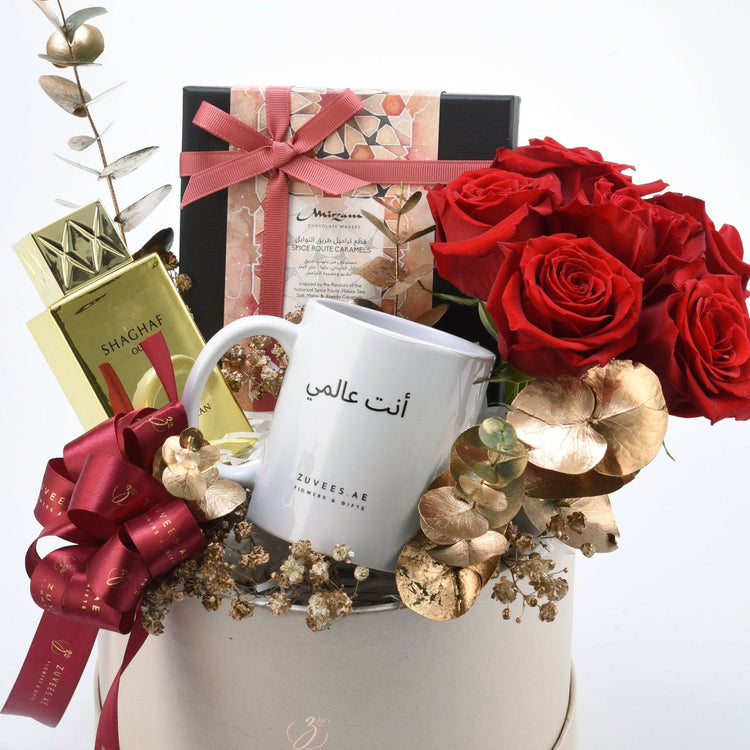 Luxury gift basket with red roses, gold accents, and personalized mug.