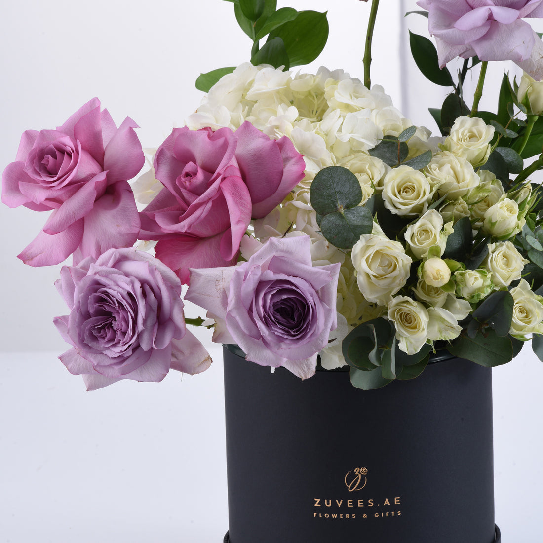 Elegant pink, purple, and white roses with hydrangeas in a sleek black Zuvees box.