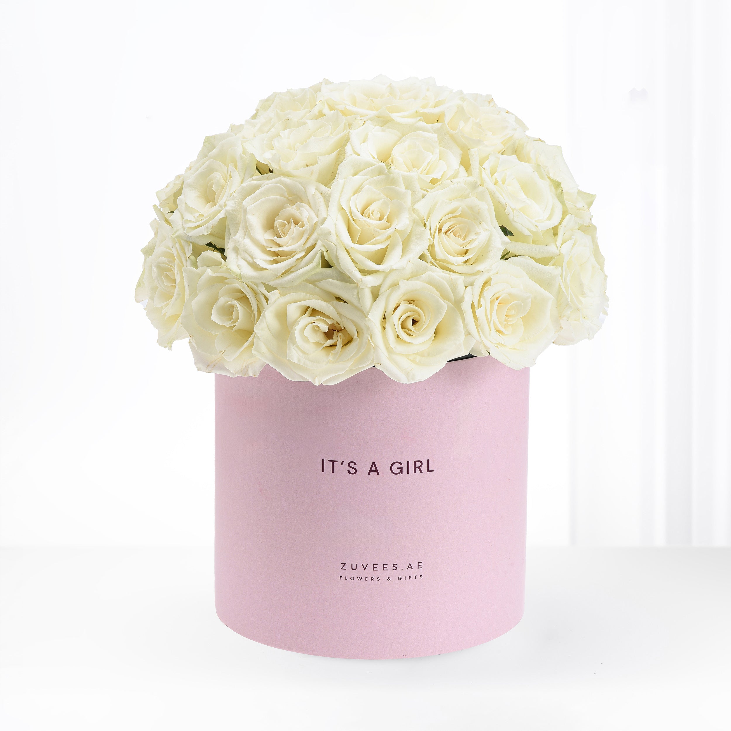 Soft cream roses in pastel pink box reading "It&