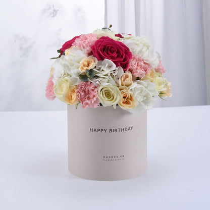 Pastel pink, white, and peach floral arrangement in a "Happy Birthday" box.