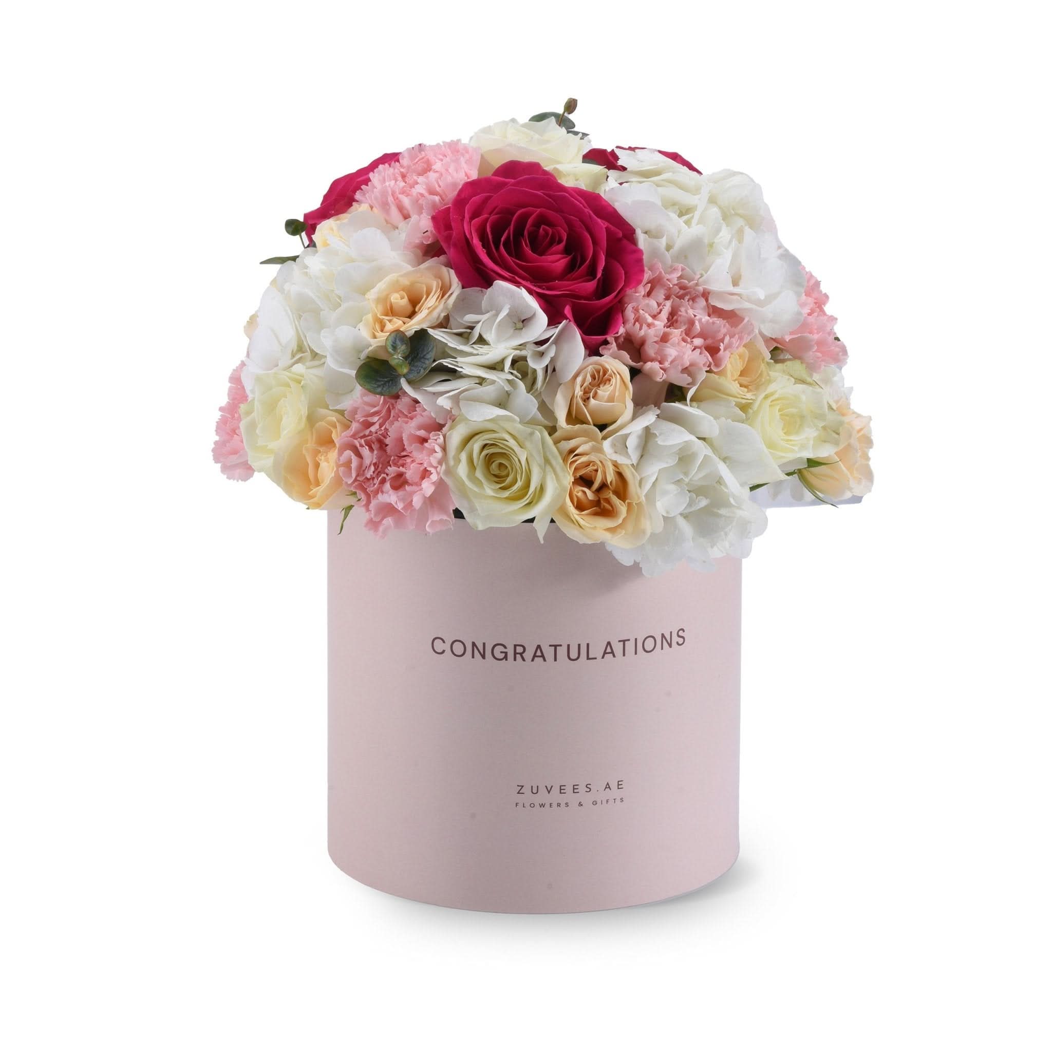 Pink box holds vibrant roses, carnations, and hydrangeas—perfect celebratory gift.