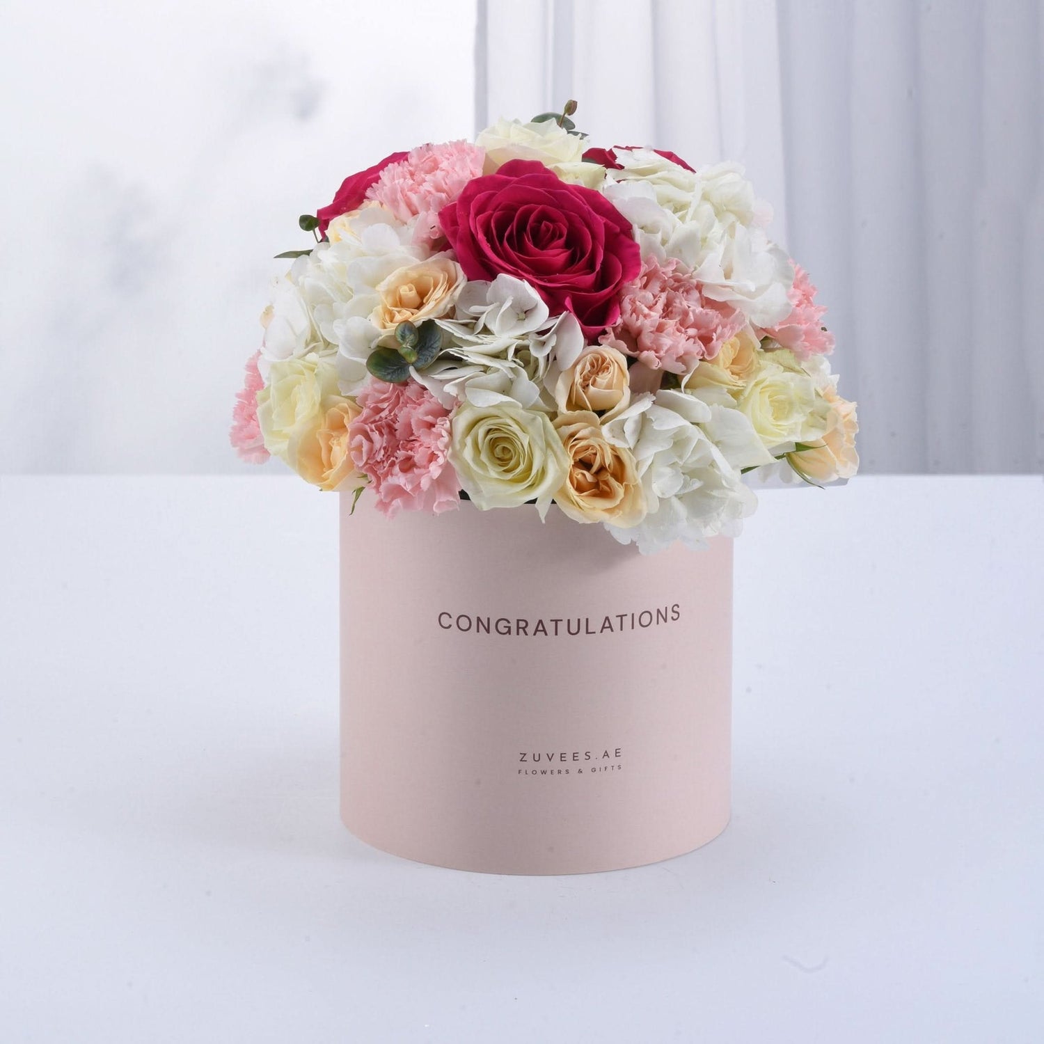 Pink box with "CONGRATULATIONS" holds vibrant roses, carnations, and hydrangeas.