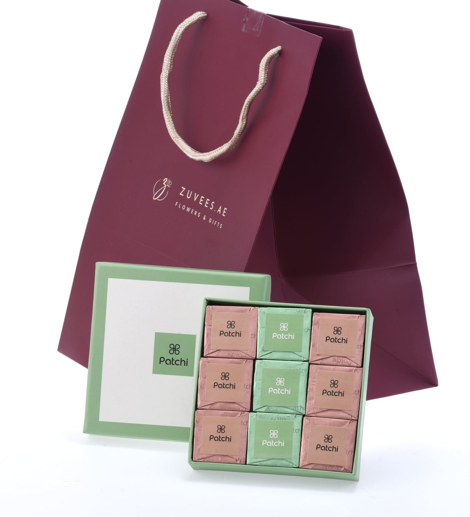 Elegant burgundy gift bag with ZUVEES.AE logo, paired with a green Patchi chocolate box.